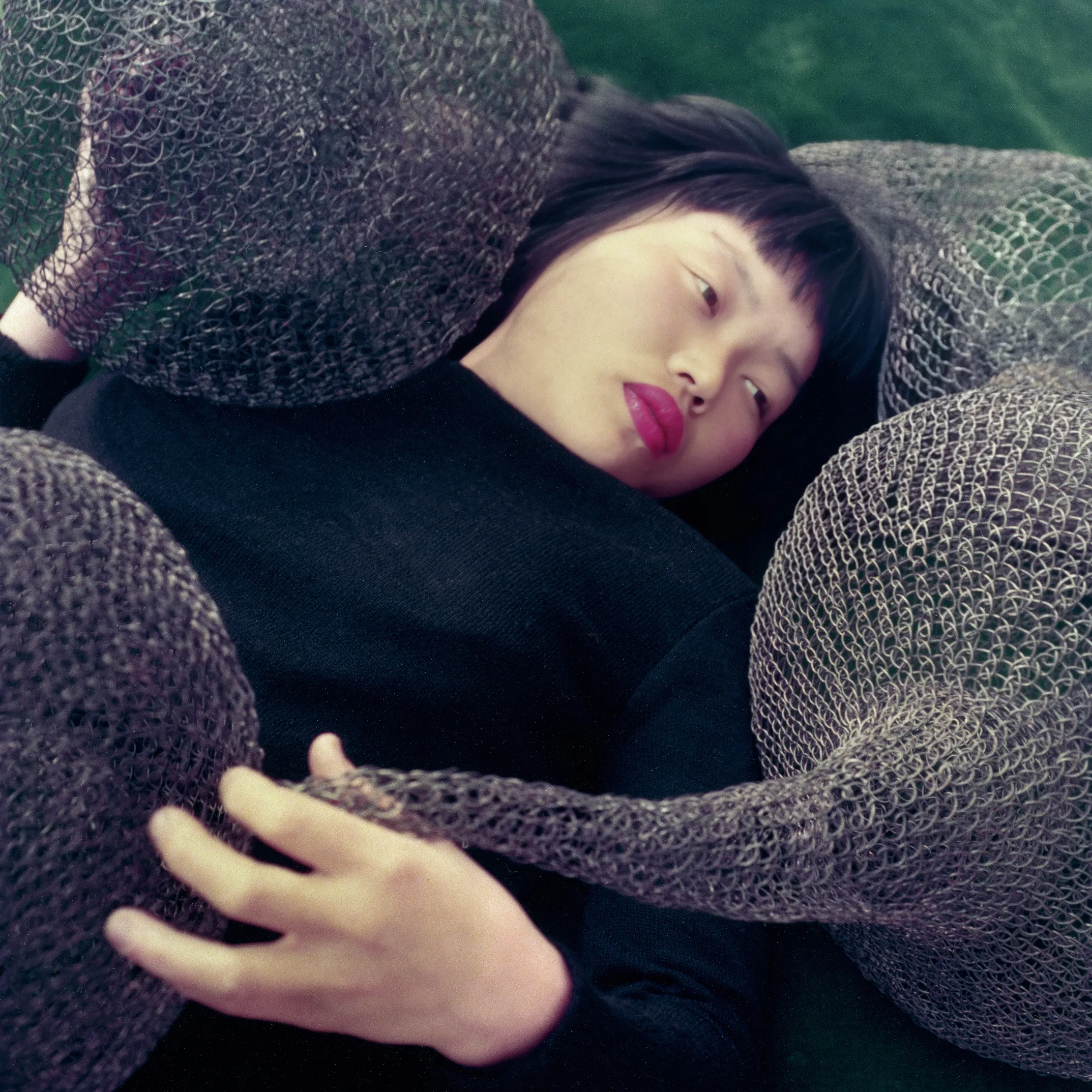 Ruth Asawa surrounded by her woven wire sculptures